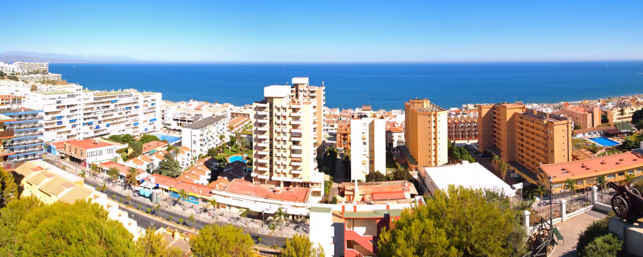 Omgevingsfoto van KOSMOS met een panoramisch luchtbeeld van het stedelijke kustgebied van Torremolinos en de Middellandse Zee, genomen vanaf Torre Mirador in Parque de la Batería