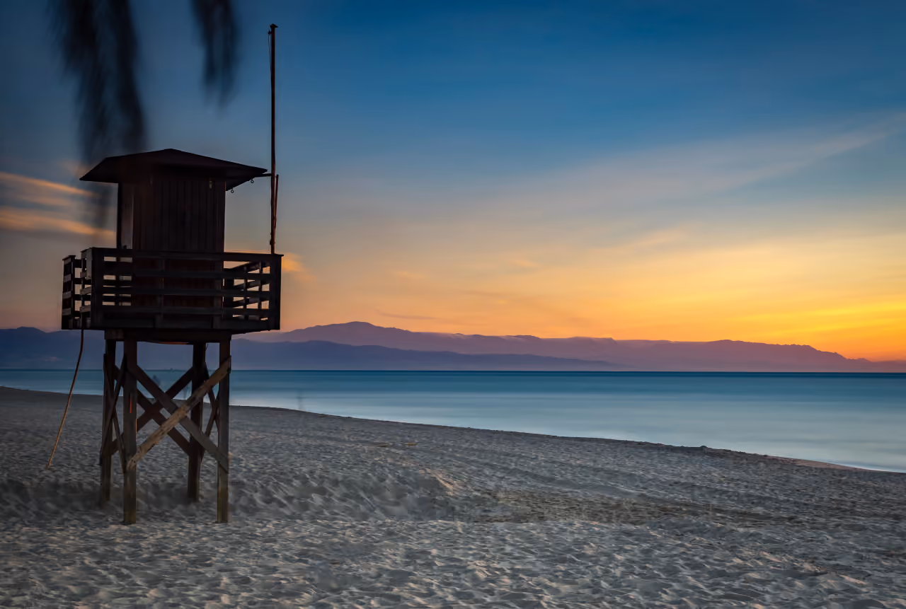 Playa de los Álamos beach bei Sonnenuntergang mit Rettungsturm, Torremolinos, Costa del Sol, nahe MAGNA TORREMOLINOS