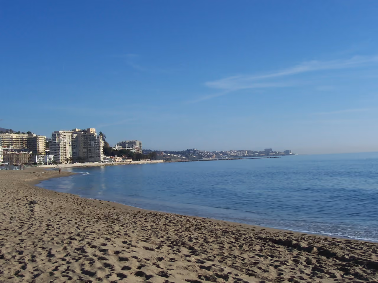 Küstenlinie des Costa-del-Sol-Strands nahe CARAT mit ruhigem Mittelmeer und Küstenapartments nahe Fuengirola/Benalmádena