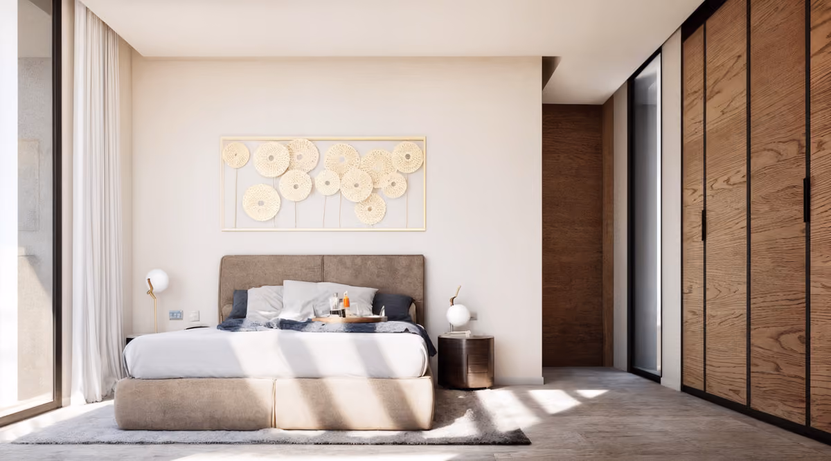 Projectvisualisatie van ELARA RESIDENCES met een taupe gestoffeerd bed, houten kastenwand, een rond donker nachtkastje, witte gordijnen en decoratieve gevlochten wandkunst in een gouden lijst.
